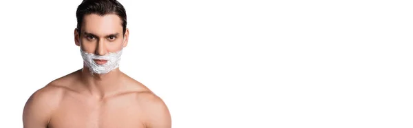 Man with bare shoulders and shaving foam on face looking at camera isolated on white, banner — Stock Photo