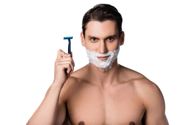 Sonriente hombre con el pecho desnudo sosteniendo la navaja de afeitar de seguridad y mirando a la cámara aislada en blanco - foto de stock