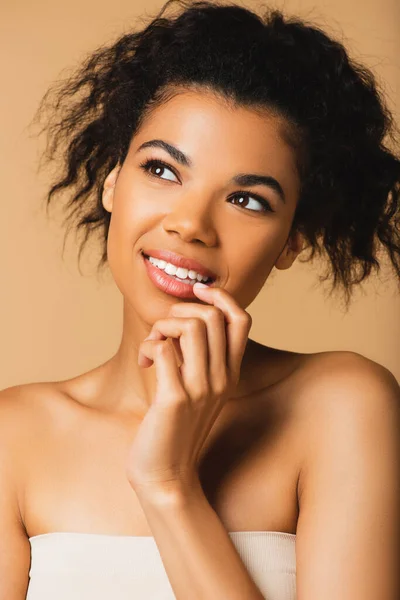 Retrato de mujer afroamericana sonriente con hombros desnudos aislados en beige - foto de stock