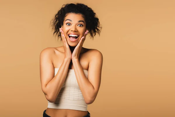 Excité afro-américain femme avec les épaules nues et bouche ouverte isolé sur beige — Stock Photo