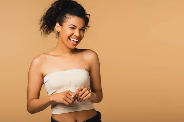 Gai afro-américaine femme avec les épaules nues winking à caméra isolé sur beige — Photo de stock