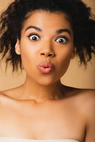 Shocked african american woman with bare shoulders isolated on beige — Stock Photo