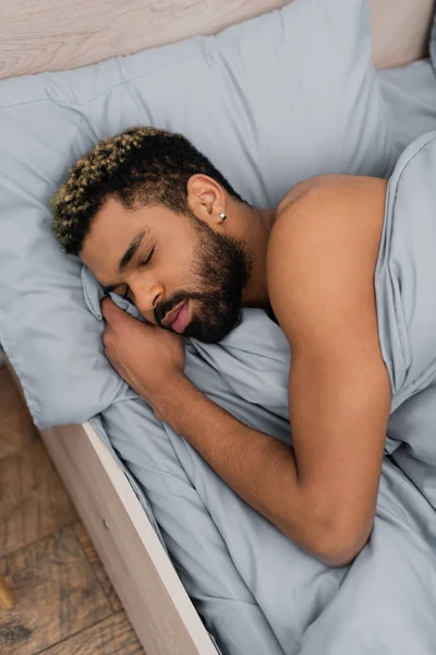 Високий кут зору бородатого афроамериканця з закритими очима, спить у ліжку — стокове фото