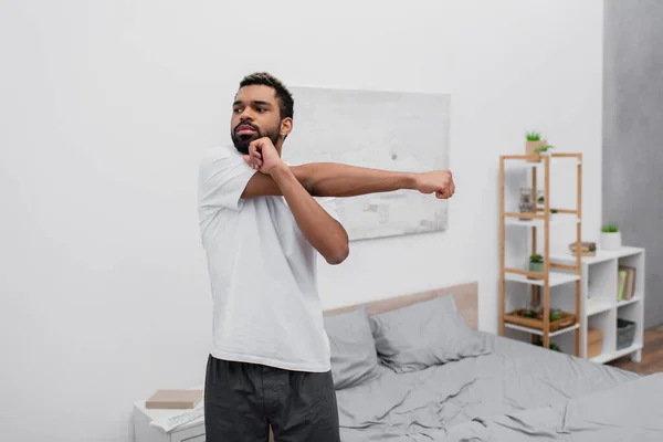 Bärtiger Afroamerikaner macht Morgengymnastik im Schlafzimmer — Stockfoto