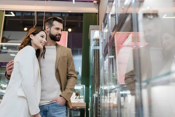 Clients heureux debout près de vitrine de la bijouterie — Photo de stock