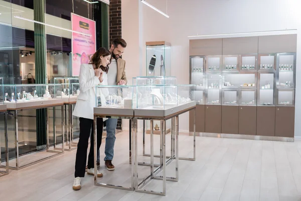 Customers choosing accessories near showcase in jewelry store — Stock Photo