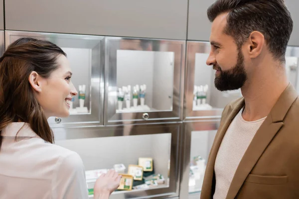 Side view of client and seller looking at each other near blurred jewelry shop — Stock Photo