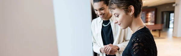 Customer and african american seller looking away in music store, banner — Stock Photo