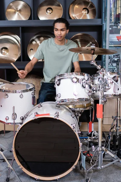 African american customer playing drums in music store — Stock Photo