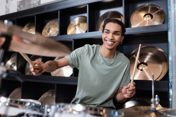 Young african american customer performing drums in music store — Stock Photo