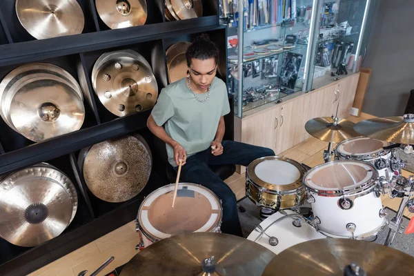 African american customer playing drum set in music store — Stock Photo