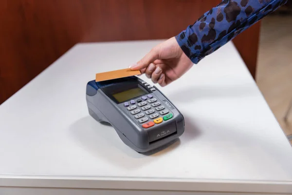 Cropped view of woman paying with credit card near payment terminal in shop — Foto stock