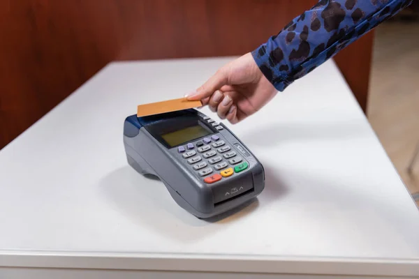 Vista recortada de la mujer que paga con tarjeta de crédito cerca de la terminal de pago en la tienda - foto de stock