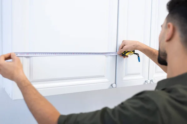 Blurred muslim man measuring kitchen cabinet at home — Stock Photo
