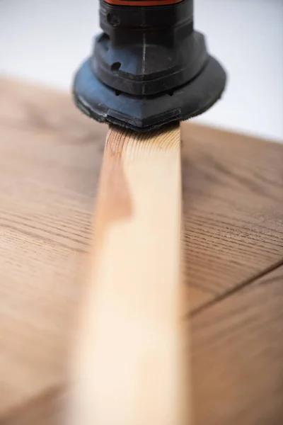 Close up view of electric sander and wooden board on table at home — Stock Photo
