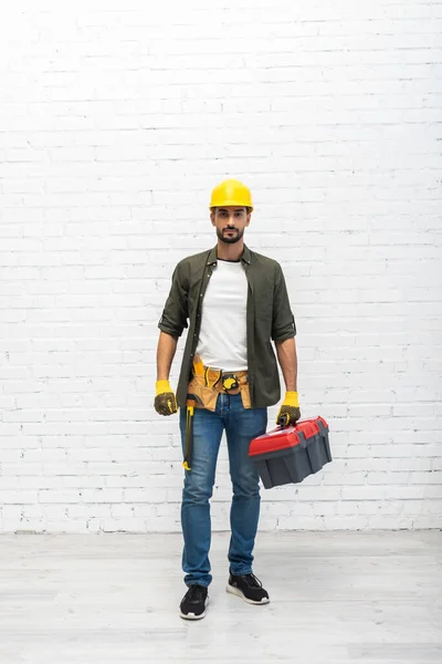 Arabian man in hardhat holding toolbox at home — Fotografia de Stock