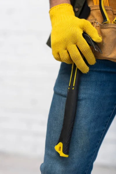 Обрезанный вид ремонтника в перчатках с молотком на поясе инструмента дома — стоковое фото