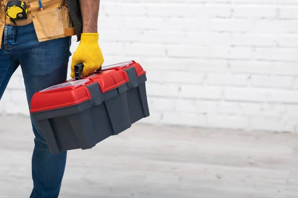 Partial view of repairman holding toolbox at home — Stock Photo