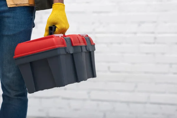 Cropped view of man in glove holding tool box at home — Foto stock