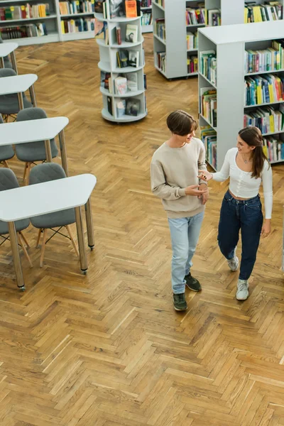 High angle view of teenage students talking and gesturing in library — Photo de stock