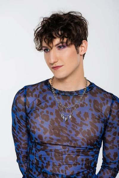 Brunette queer model in long sleeve shirt and silver necklaces isolated on grey — Photo de stock