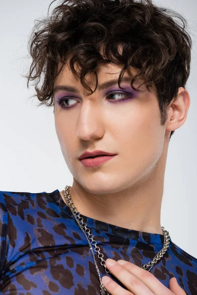 Portrait of queer person with makeup and wavy hair isolated on grey — Stock Photo