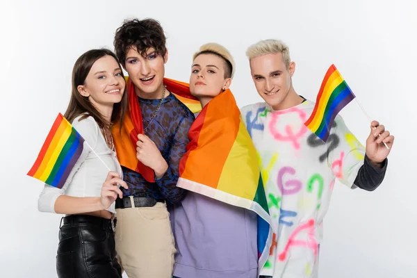 Smiling lgbtq community people with rainbow flags looking at camera isolated on grey — Foto stock