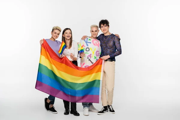Full length of diverse identity friends standing with lgbtq flags on grey background — Foto stock