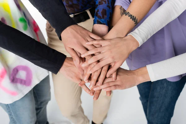 Partial view of lgbtq community people joining hands on white background — стоковое фото