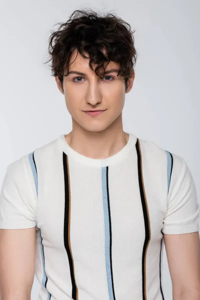 Young brunette man in striped t-shirt looking at camera isolated on grey — Stock Photo