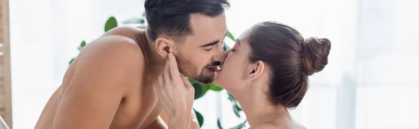 Uomo senza maglietta con busto muscolare baciare giovane ragazza a casa, banner — Foto stock
