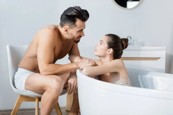 Sem camisa homem em cuecas tocando sexy namorada tomando banho em casa — Fotografia de Stock
