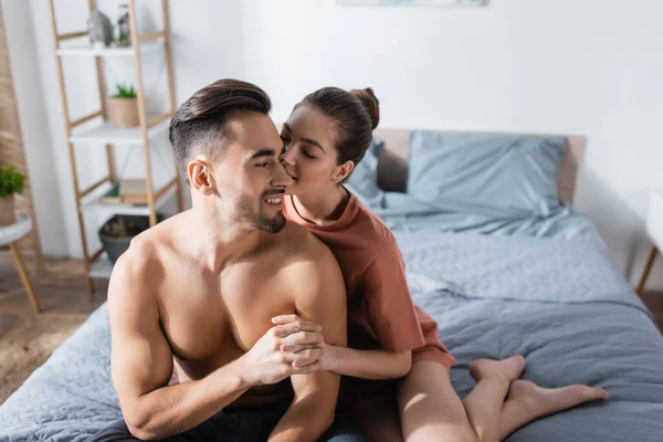 Чувственная женщина, держась за руки с сексуальным парнем, целуя его в спальне — стоковое фото