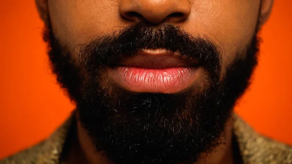Primer plano de hombre afroamericano recortado y barbudo aislado en naranja - foto de stock