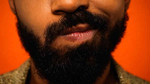 Close up de homem afro-americano cultivado e incerto isolado em laranja — Fotografia de Stock