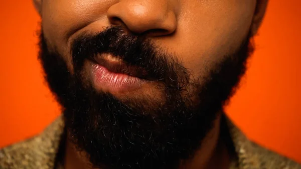 Close up of cropped and doubtful african american man isolated on orange — Stock Photo