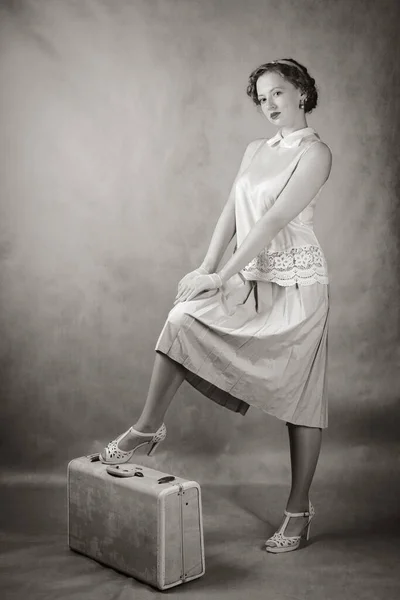 一个穿着复古风格衣服的年轻女人站在手提箱上 黑白照片演播室 — 图库照片