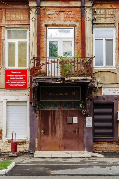 Orenburg, Rusya - Eylül 04, 2021: Girişin üzerinde dövülmüş demir bir balkon bulunan eski bir binanın ön cephesi. Tabaktaki yazı: dikkat! Kültür mirası sahası koruma altında