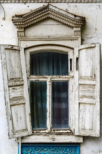 木製のシャッターとファサードにStucco要素を持つ古い家の彫刻フレームを持つウィンドウ 写真はロシアのオレンブルクで撮影されました — ストック写真