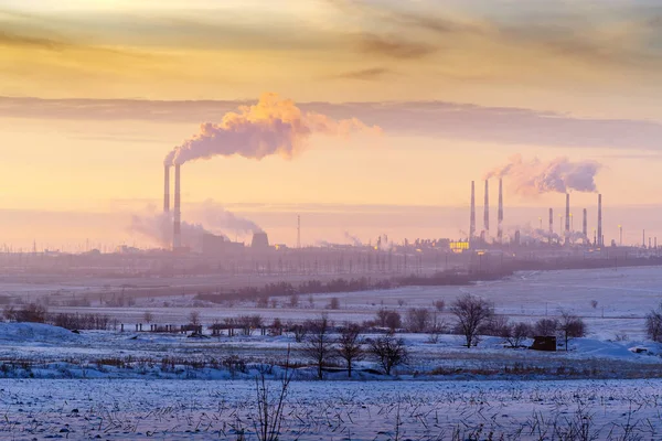 Gün batımında bacalar ve soğutma kuleleri. Ufukta birleşik bir ısı, elektrik santrali ve gaz işleme tesisi var. Fotoğraf Rusya 'da, Orenburg şehrinin yakınlarında çekildi.