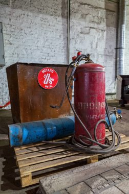 Gas torch for manual metal cutting and compressed propane and oxygen cylinders. The picture was taken in Russia, in the factory shop