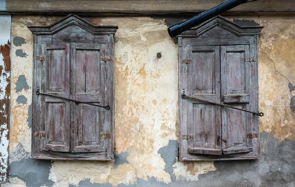 Два Окна Закрытыми Ставнями Старого Деревянного Дома Треснувшей Штукатуркой Фрагмент — стоковое фото