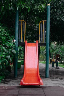 Şehir parkının oyun parkında kayan boş renkli metal çocuğun ön görüntüsü