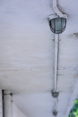 Beyaz tavanda demir endüstriyel ışıklar var.