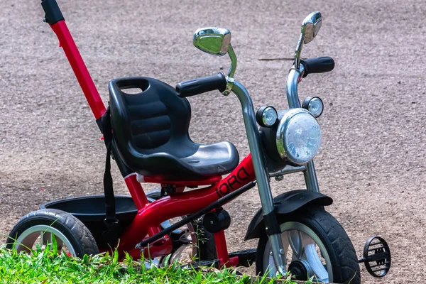 Fekete Piros Kisgyerek Tricikli Parkolás Mellett Zöld Nyilvános Park — Stock Fotó