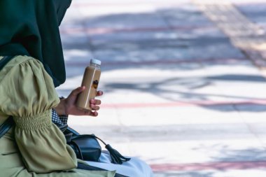 İki genç kız şehrin kaldırımında birlikte vakit geçirir, konuşur ve otururlar.