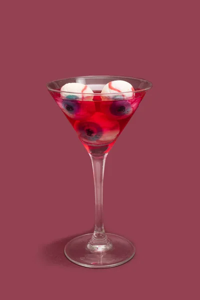 ホラー不気味な飲み物のコンセプト マルティーニグラスフルともに眼球赤い色ドリンクに対してダーク梅の背景 — ストック写真