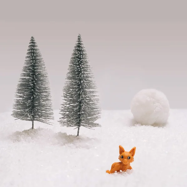 Jack Frost inspired concept. Minimal arrangement with little toy fox, two trees and avalanche in background.