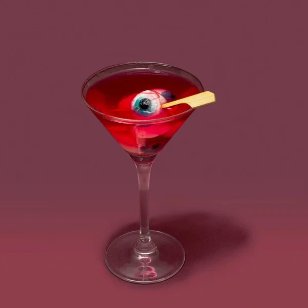 悪魔の畏敬の念を飲む概念 マルティーニグラスフルともに眼球赤い色ドリンクに対して桑の紫色の背景 — ストック写真