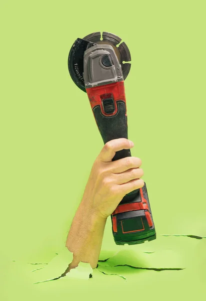 Man Hand Holds Brushless Cordless Angle Grinder Breaks Green Ground — стокове фото